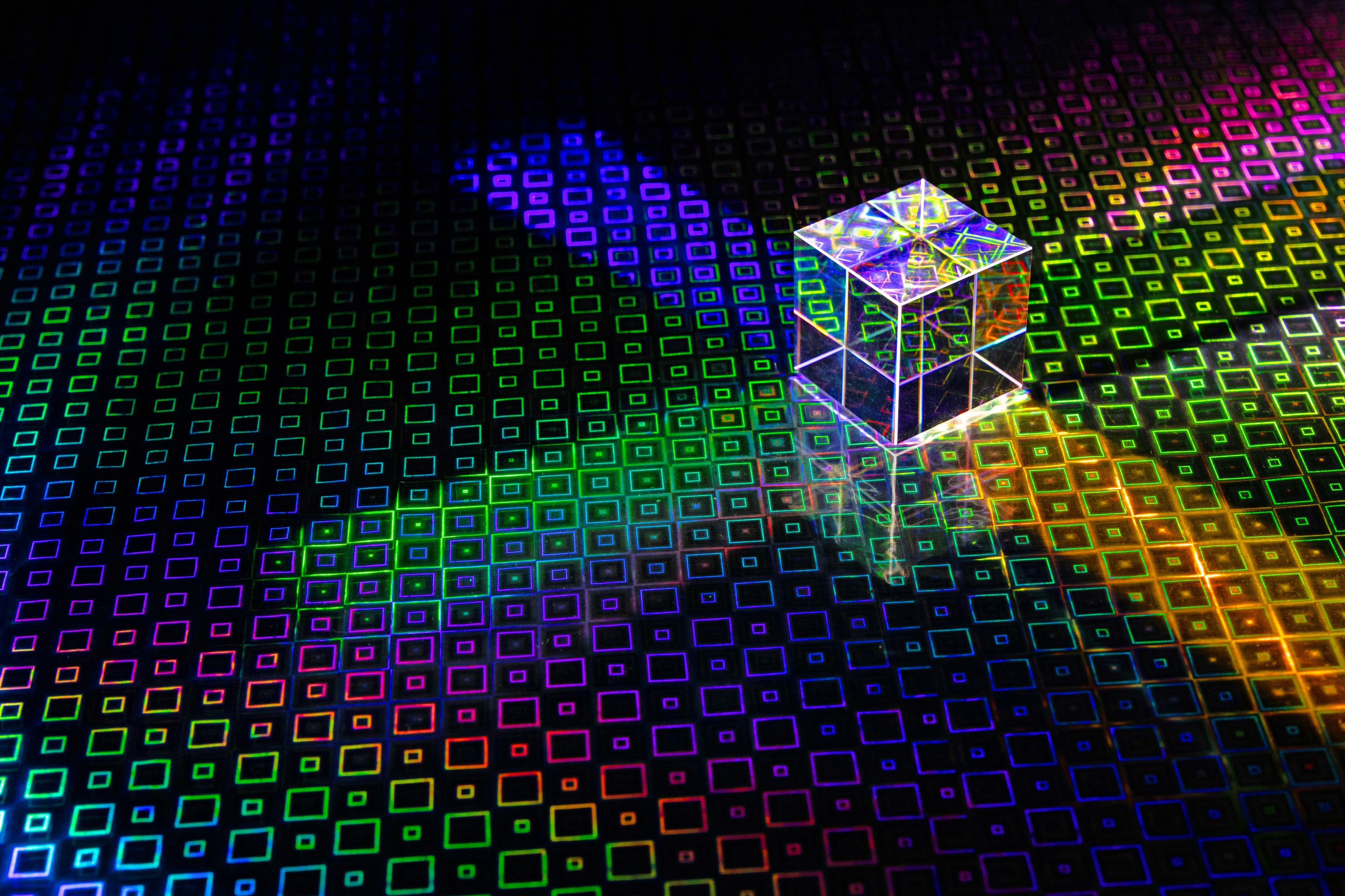 A perspex cube appears to radiate light across a surface designed with squares. (David Clode/Unsplash)