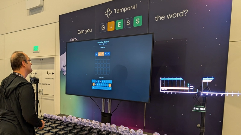 Attendee playing durable wordle next to holographic fans