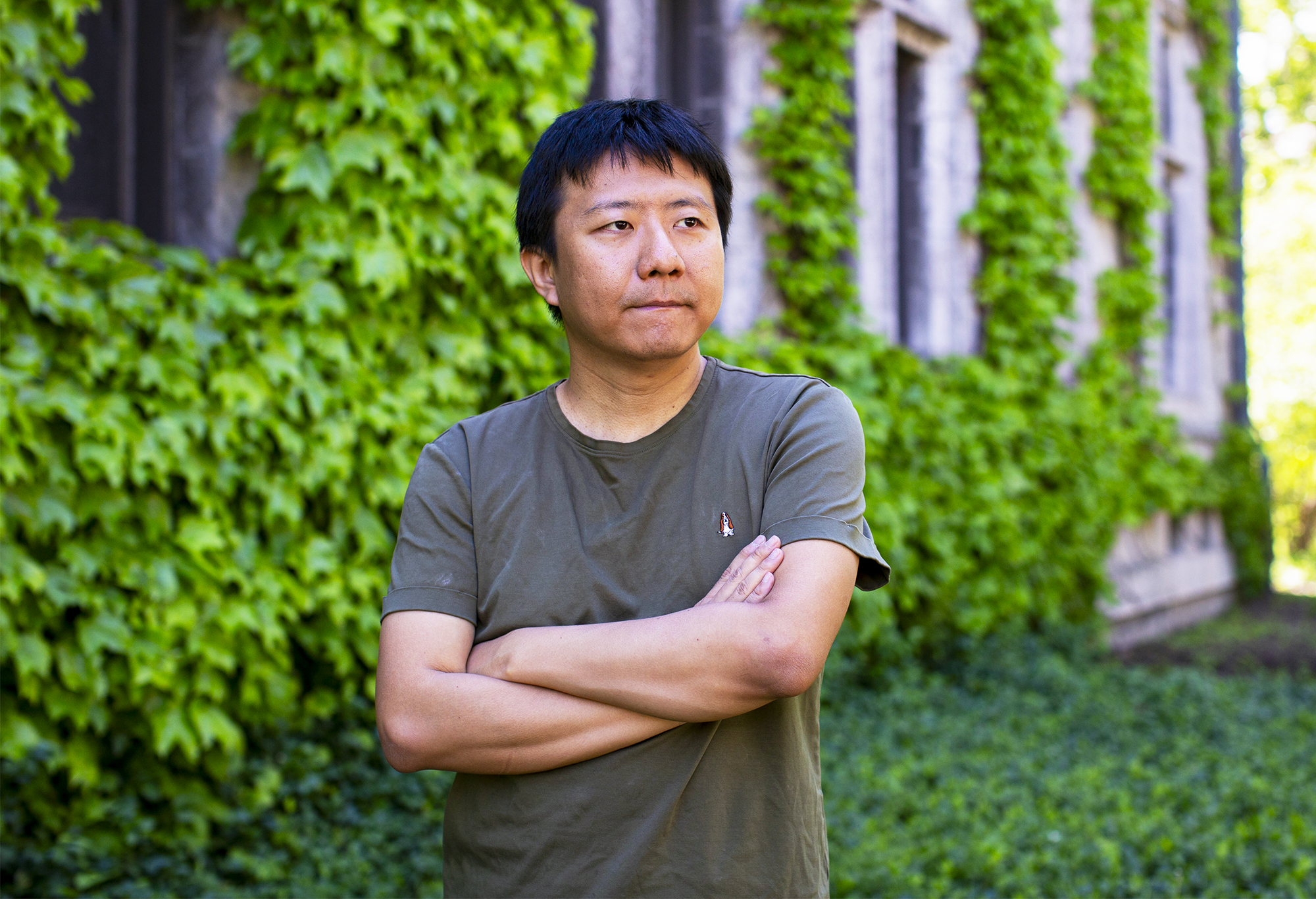 A man in a green shirt with his arms crossed.