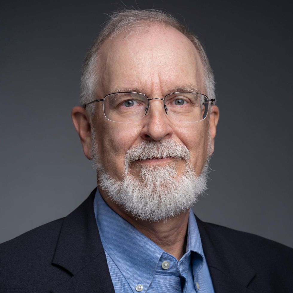 Older white man with a white beard and glasses.