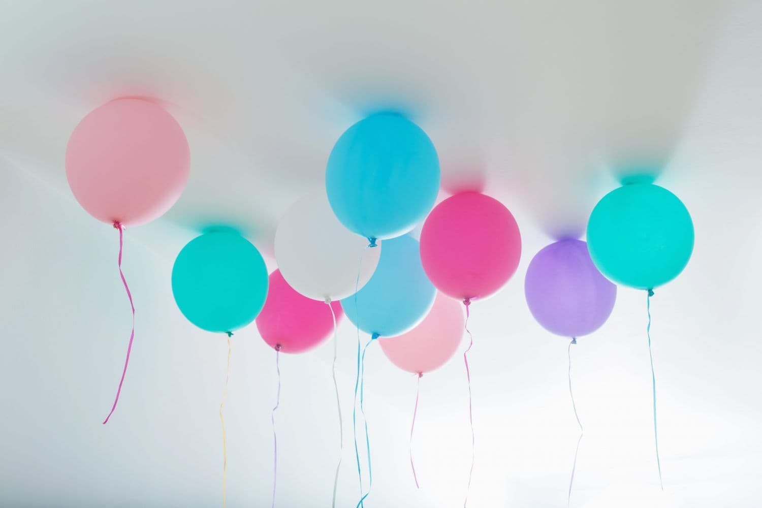 Several balloons float against the ceiling