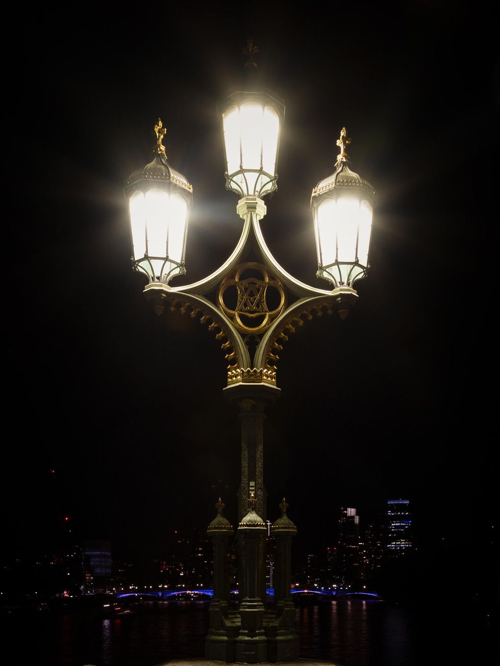Three lanterns glow white in the night.
