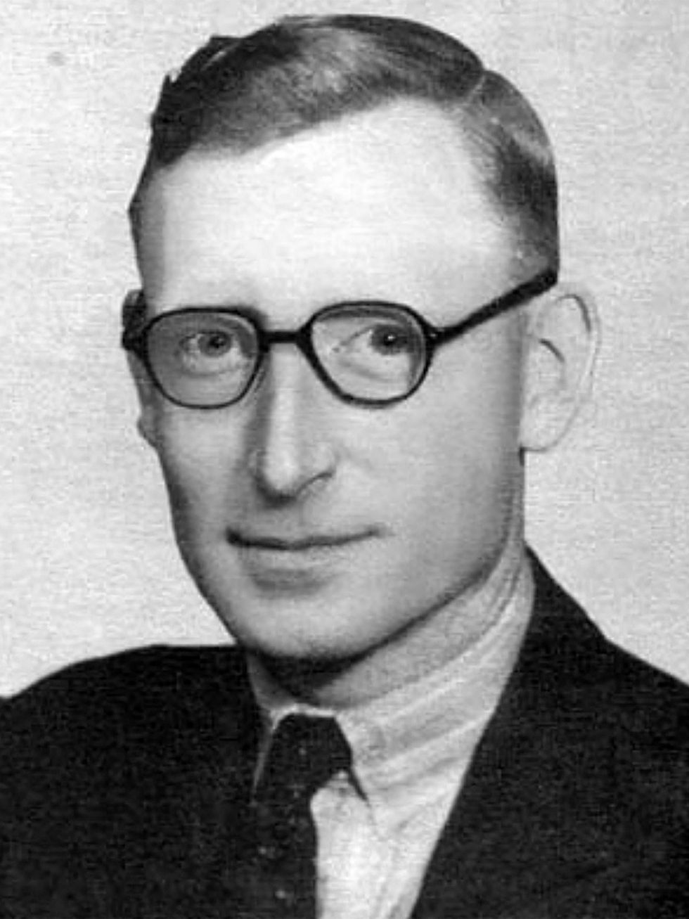 Black and white portrait of a man with short gelled hair in a suit jacket, tie and eyeglasses.