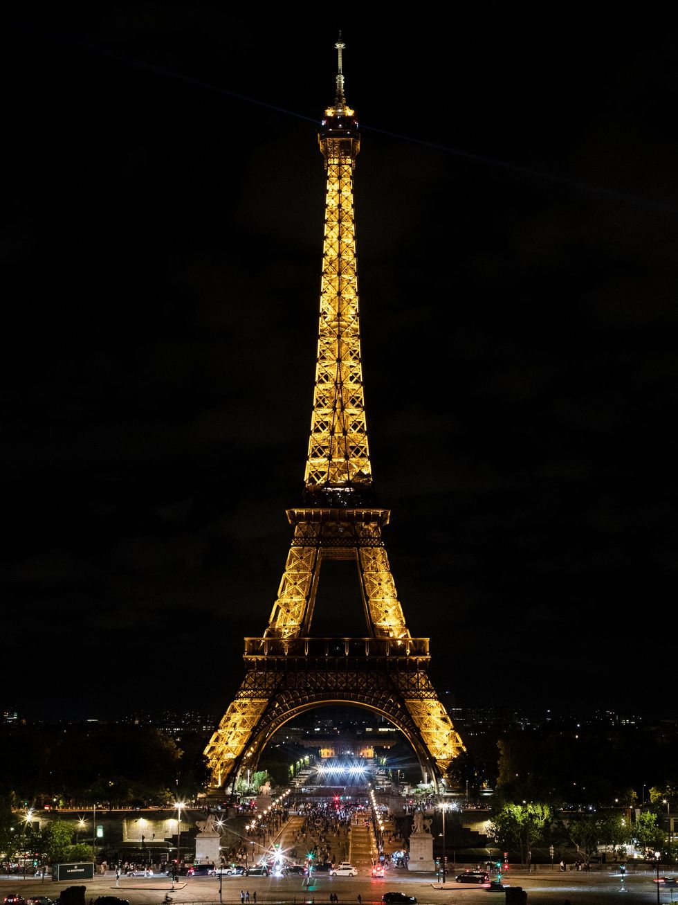 The Eiffel Tower glows with warm golden illumination at night.