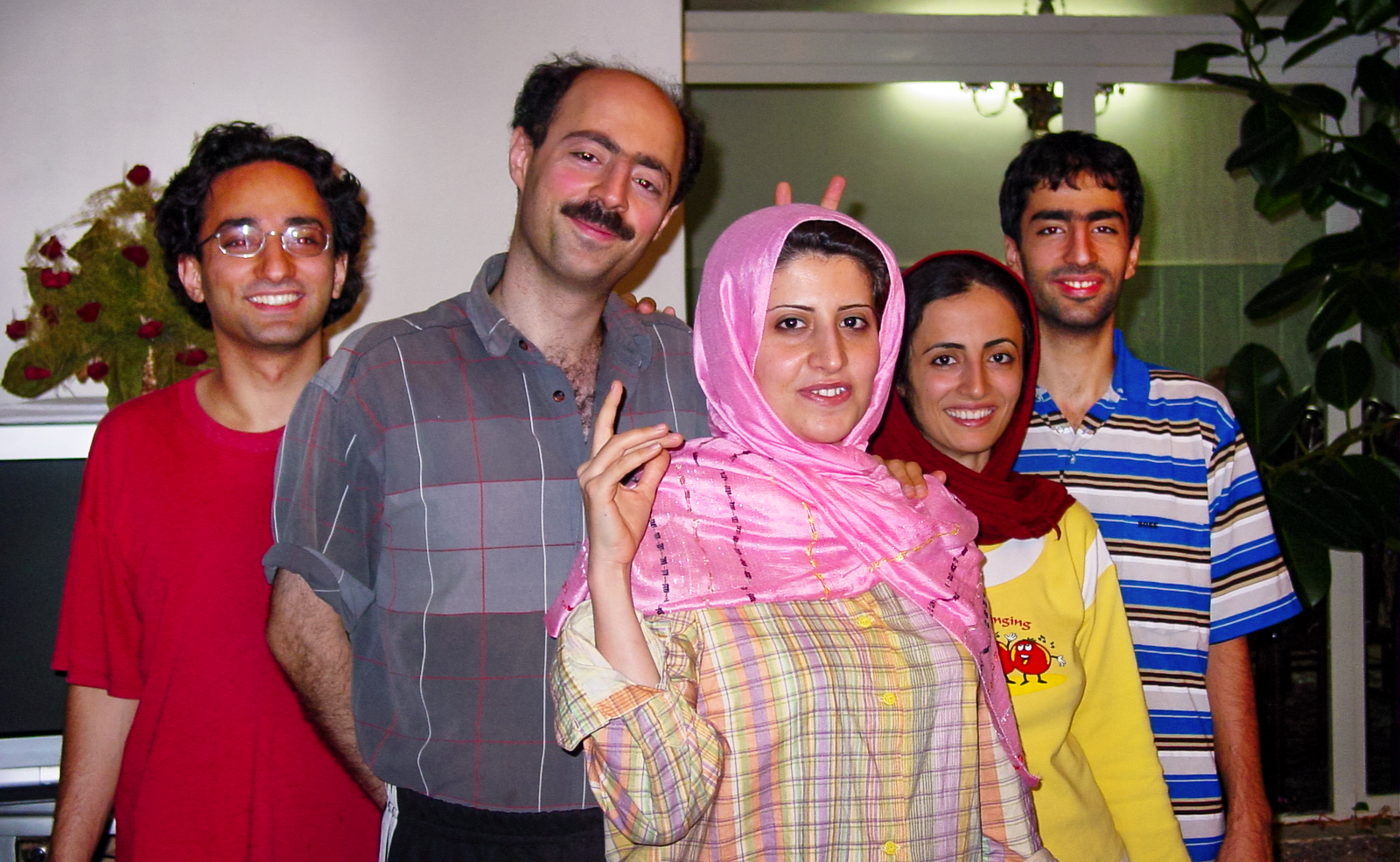 An old photo of Shayan Oveis Gharan and his four siblings when they were younger. They are posing together indoors, smiling for the camera; one woman playfully holds up two fingers behind another's head.