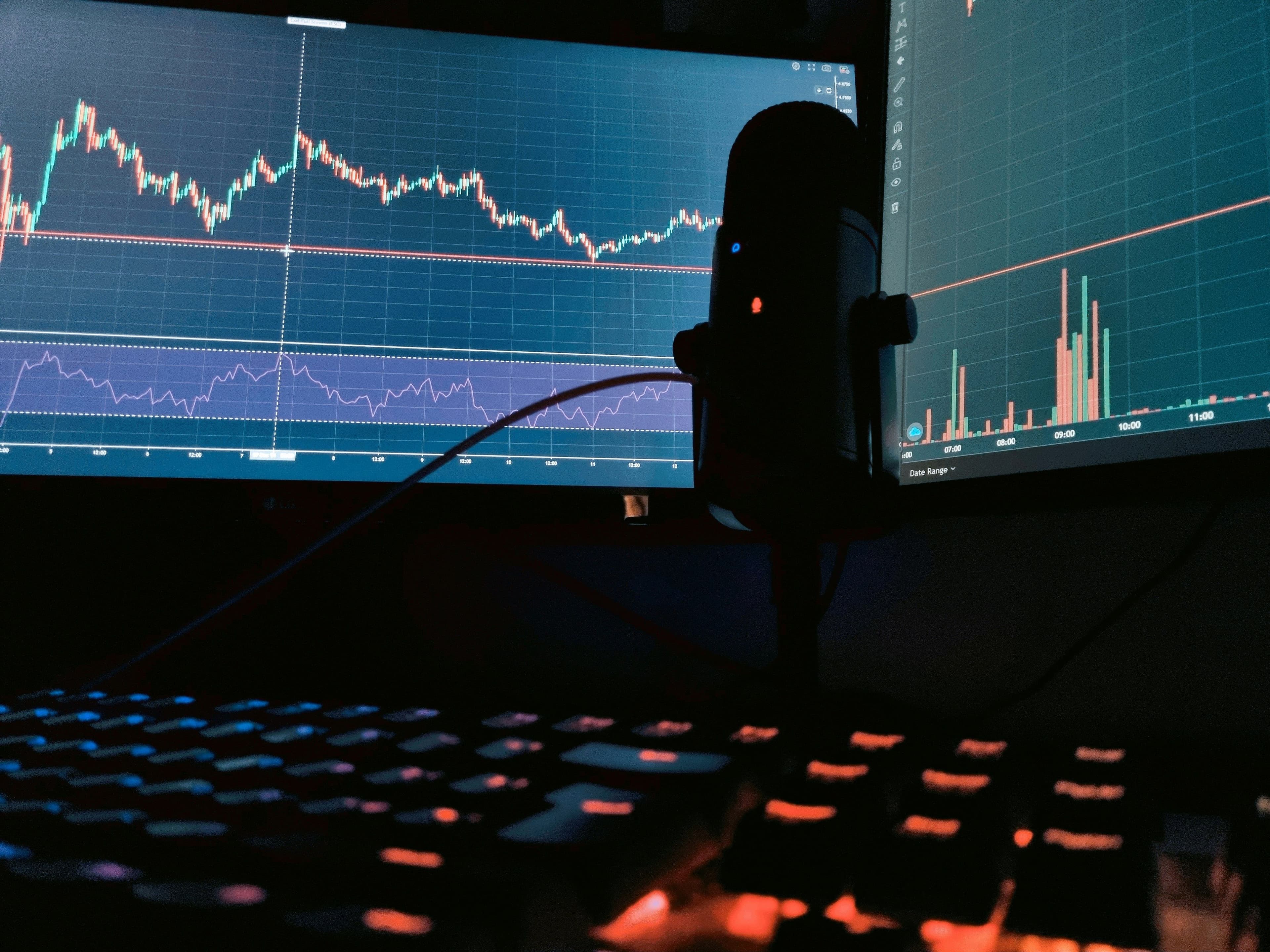 Two charts and keyboard in a darkened room. (Asa E K/Unsplash)